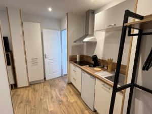 a kitchen with white cabinets and a counter top at Appart Cosy in Hesdin