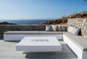 patio z kanapami i oceanem w tle w obiekcie Rising Sun sea view Villa near the beach Paros w mieście Molos Parou