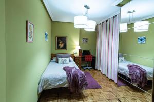 a bedroom with two beds and a mirror at Luminoso apartamento en Grado, cerca de Oviedo in Grado