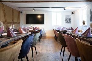 a dining room with tables and chairs and a flat screen tv at Anni`s Inn in Bruchsal