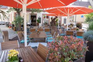 an outdoor restaurant with wooden tables and umbrellas at Anni`s Inn in Bruchsal