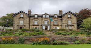 an old stone house with a garden in front of it at B/W Plus Buxton Lee Wood Hotel in Buxton