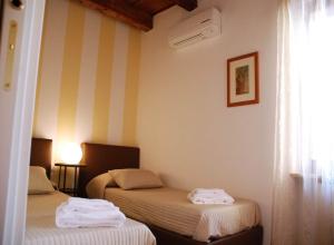 duas camas num quarto com paredes listradas em Stella Luxury Home em Verona
