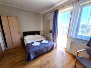 a bedroom with a bed with two towels on it at Willa Maczek in Sztutowo