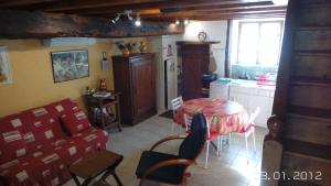 a kitchen with a table and chairs in a room at la petite fontaine in Écuras