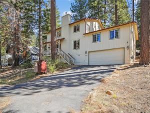 une grande maison avec un garage dans les bois dans l'établissement High Sierra Escape - Cozy, Spacious Mountain Home, à South Lake Tahoe
