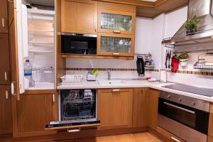 a kitchen with wooden cabinets and a dishwasher at Luminoso apartamento en Grado, cerca de Oviedo in Grado