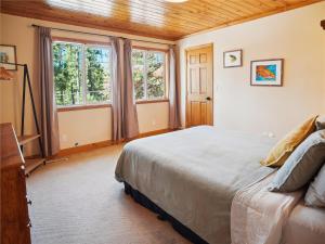 - une chambre avec un grand lit et des fenêtres dans l'établissement High Sierra Escape - Cozy, Spacious Mountain Home, à South Lake Tahoe