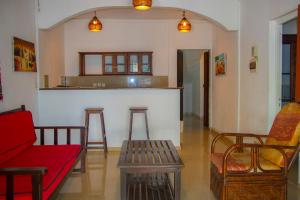 a living room with a couch and chairs and a bar at Résidence Kambana in Nosy Be