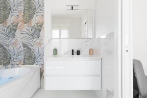 a bathroom with a white sink and a mirror at House White Puglia by BarbarHouse in Fasano