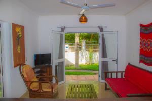 a living room with a red couch and a tv at Résidence Kambana in Nosy Be