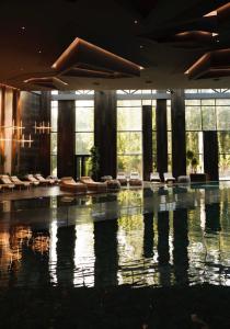 a swimming pool in a hotel with chairs and windows at Natural Pool & SPA in Ferizaj +20 photos