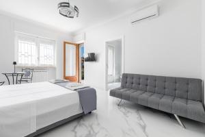 a bedroom with a bed and a couch at House White Puglia by BarbarHouse in Fasano