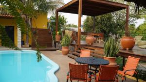 un patio con tavolo e sedie accanto alla piscina di Rancho Sayar - Coxim- Mato Grosso do Sul a Coxim