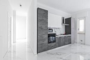 a kitchen with white walls and a large wooden cabinet at House White Puglia by BarbarHouse in Fasano +15 photos