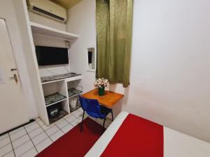 a small room with a table and a blue chair at São Luís Hostel - Dormitórios Compartilhados e Quartos Privativos in São Luís