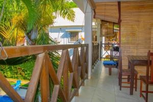 a balcony of a house with a table and chairs at Résidence Kambana in Nosy Be