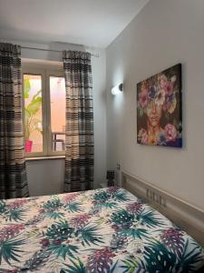 a bedroom with a bed and a painting on the wall at Nuovo trilocale vicino centro/mare in Santa Teresa Gallura