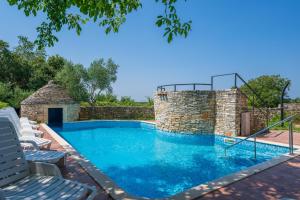 una piscina con sillas y una pared de ladrillos en Villa Arco, en Svetvinčenat