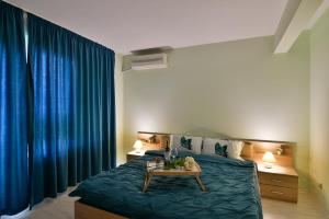 1 dormitorio con 1 cama con cortinas azules y mesa en Central Paradise - free parking, en Varna