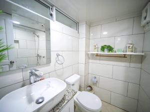 a white bathroom with a sink and a toilet at Central 1BR APT - 1 minute Walking from Rumba in Sosúa