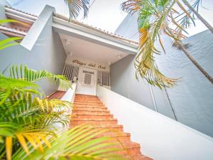 a staircase leading up to a house with palm trees at Central 1BR APT - 1 minute Walking from Rumba in Sosúa