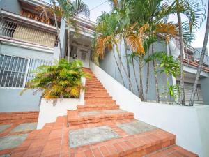 a staircase leading up to a house with palm trees at Central 1BR APT - 1 minute Walking from Rumba in Sosúa