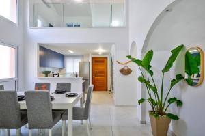 a kitchen and dining room with a table and chairs at Aphrodite Gardens Stunning Villa by VICHY Holidays in Paphos