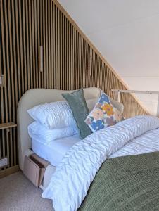 a bed with pillows on it in a room at TinyTin home on the ocean in Brighton & Hove