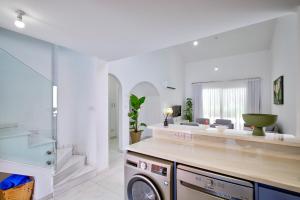 a kitchen with a washer and dryer in a room at Aphrodite Gardens Stunning Villa by VICHY Holidays in Paphos