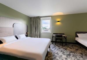 Ένα ή περισσότερα κρεβάτια σε δωμάτιο στο B&B HOTEL Compiègne Thourotte