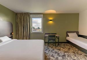 Ένα ή περισσότερα κρεβάτια σε δωμάτιο στο B&B HOTEL Compiègne Thourotte
