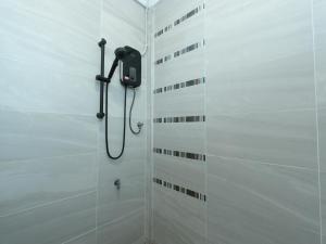 a shower in a bathroom with a black shower head at Lyd's Home Urban Staycation in Sibu +41 photos