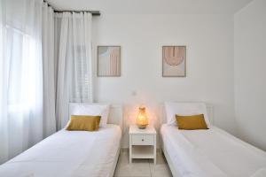 two beds sitting next to each other in a bedroom at Aphrodite Gardens Stunning Villa by VICHY Holidays in Paphos +24 photos