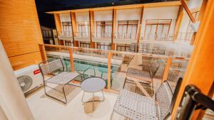 a balcony with chairs and a table and a pool at Grand Palm Villas & Hotel in Tagum
