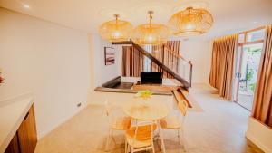 a dining room with a table and chairs and chandeliers at Grand Palm Villas & Hotel in Tagum