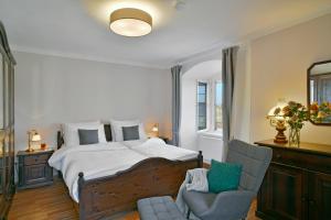 a bedroom with a large bed and a chair at Schlosshotel Harburg in Harburg +28 photos