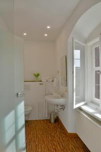 a white bathroom with a sink and a toilet at Schlosshotel Harburg in Harburg