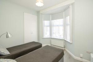una camera da letto con due letti e una finestra di 2 bed, FREE parking, SKY a Bedford