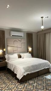 a bedroom with a large bed with white sheets and pillows at فندق فاتوران vatoran hotel in Al Madinah