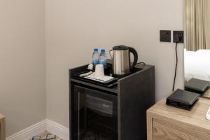 a night stand with a coffee maker and water bottles on it at فندق فاتوران vatoran hotel in Al Madinah