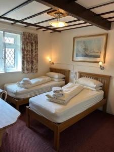 a room with three beds in a room at Oakwood Bed and Breakfast Heathrow in Hillingdon +57 photos