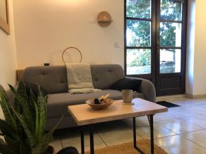 ein Wohnzimmer mit Sofa und Tisch in der Unterkunft L'Hospitalier in Saint-Antoine