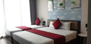 Hoằng HóaFlamingo Ibiza Hải Tiến 1723-1725的两间带红色枕头的酒店客房 更多46张照片