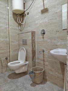 a bathroom with a toilet and a sink at Stayhomestays Grande in Bengaluru