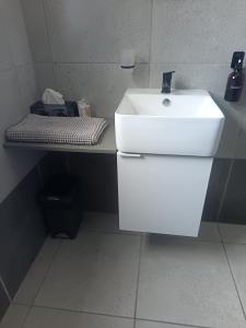 a bathroom with a white sink and a counter at Millennial Arch in Langebaan +10 photos