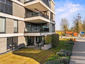 an apartment building with a balcony with tables and chairs at STAYS Werft - Luxus in erster Seereihe in Kressbronn am Bodensee