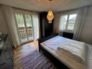 a bedroom with a bed and two large windows at Nevita in Saas-Grund