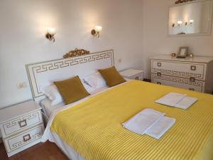 a bedroom with a large yellow bed with two towels on it at Talia apartments & pool in Dobra Voda +132 photos