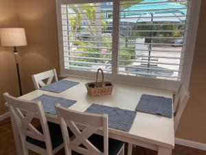 a dining room table with chairs and a window at Palm Haven Beach Side Villa in Holmes Beach